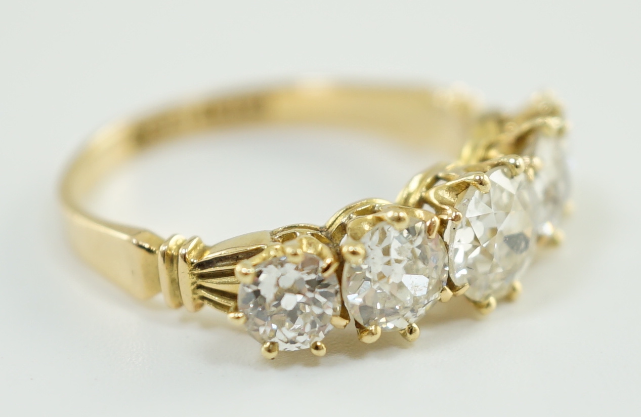 An 18ct gold and graduated five stone diamond set half hoop ring